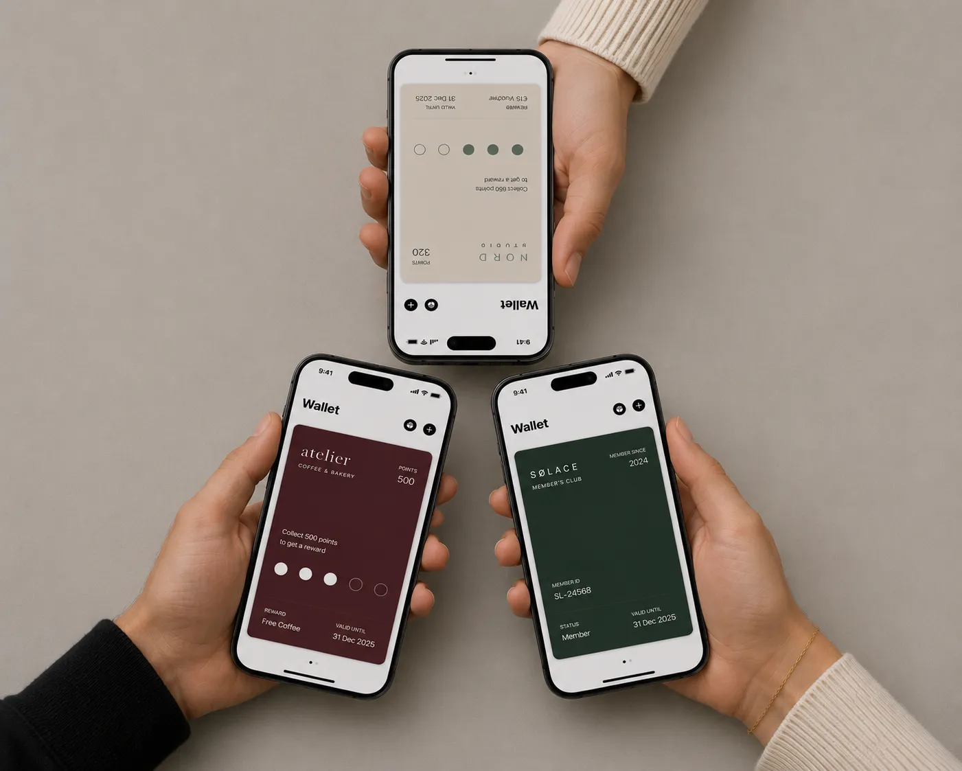 Trois personnes tiennent chacune leur iPhone, affichant dans Apple Wallet la carte de fidélité d’un commerce différent : un café-boulangerie, un studio et un club